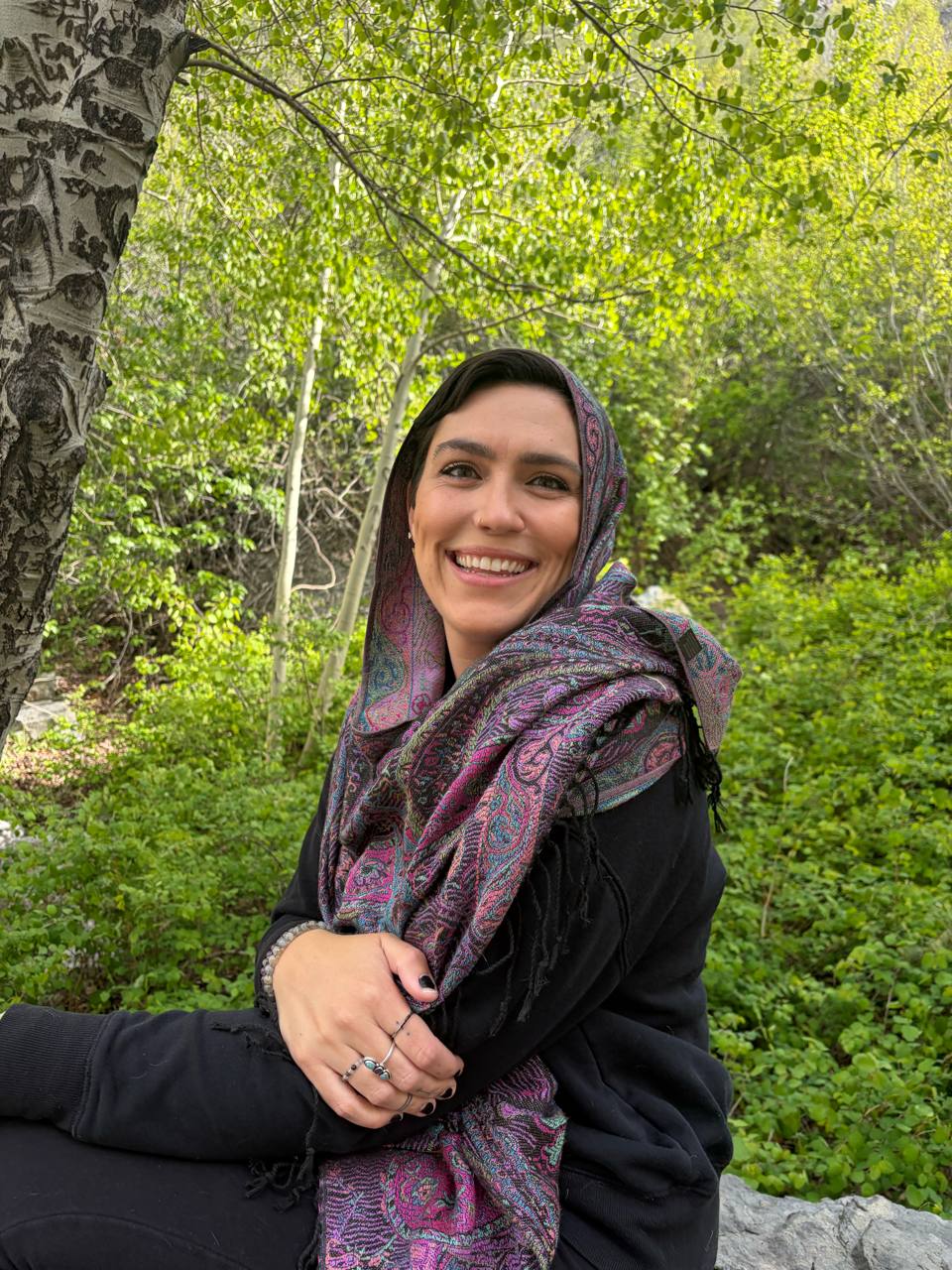 Jana, founder of ALIRA, seated among aspen trees